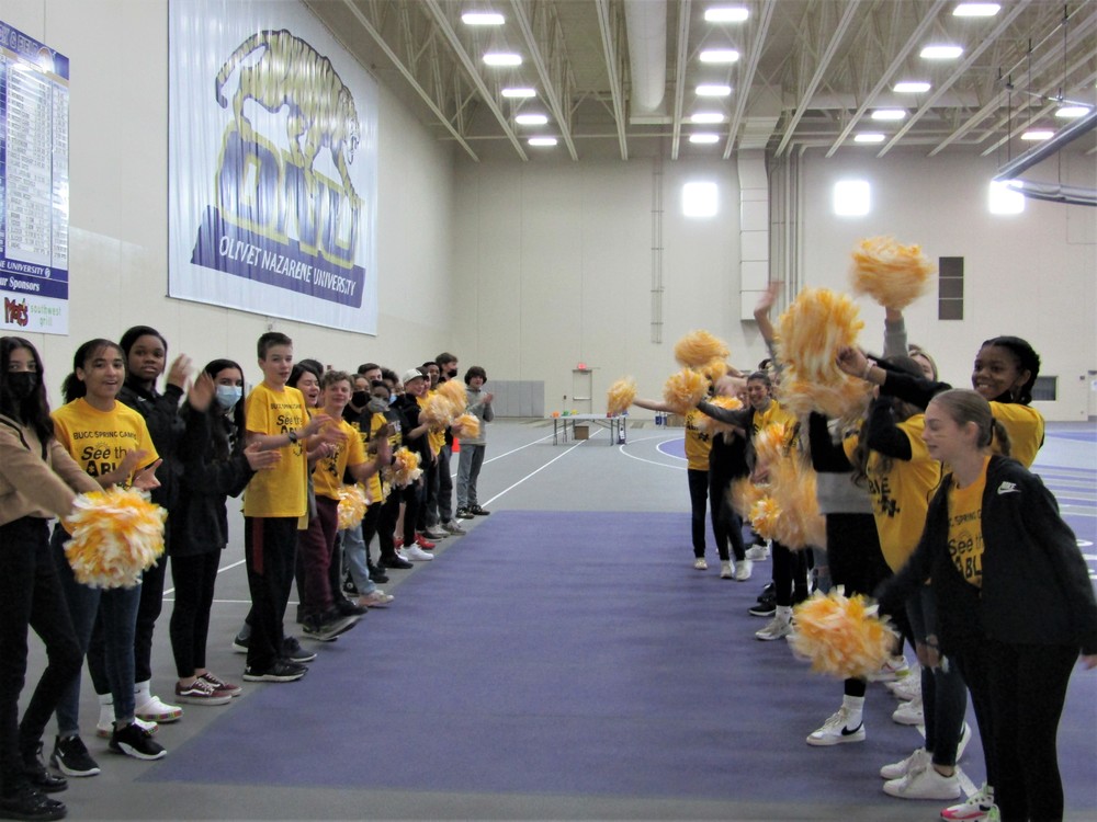 Spring Games - image of students lined up on sides of an aisle cheering