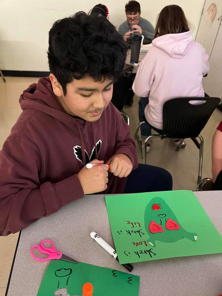 Student making their Valentine Day Project on Green paper