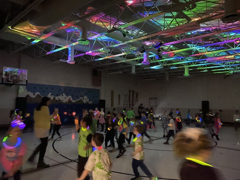 Students in the gym with glow sticks and fun lights